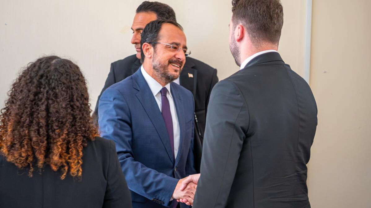 The Greek Cypriot leader, Nikos Christodoulides, shakes his hand.
