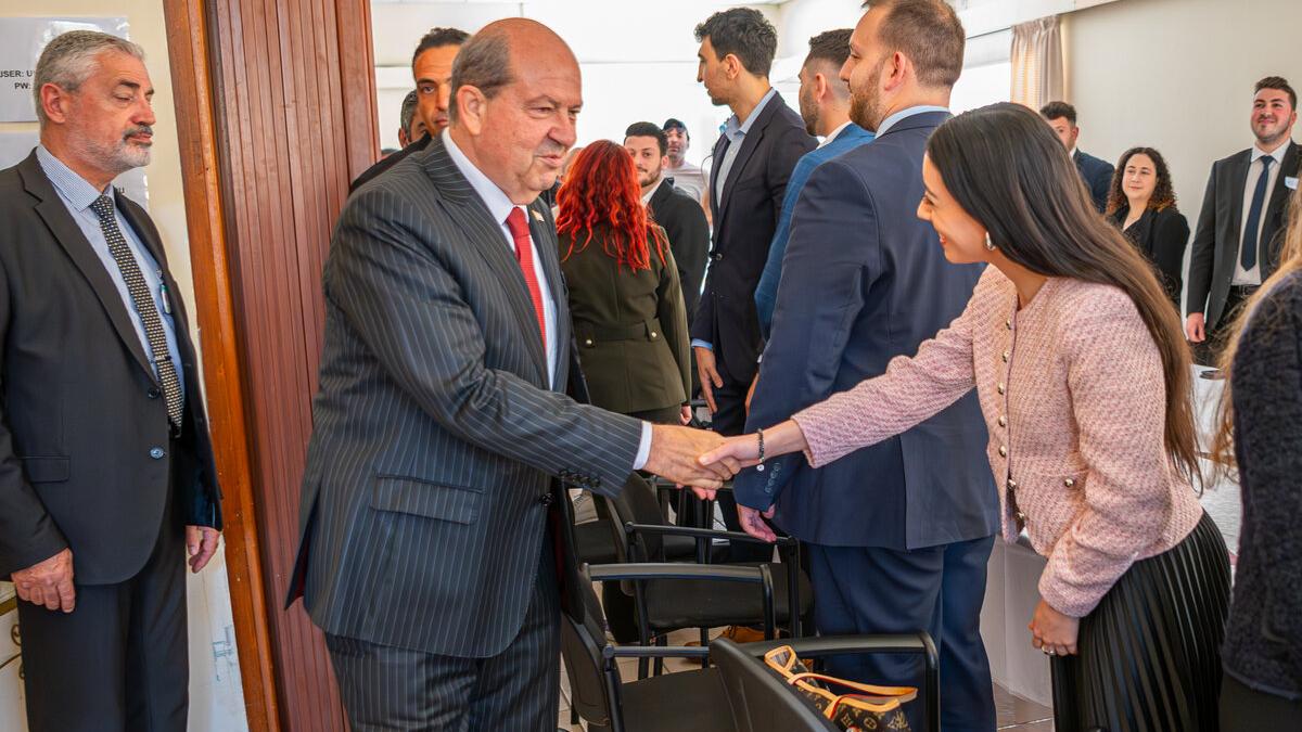 The Turkish Cypriot leader, Ersin Tatar, shakes his hand. 