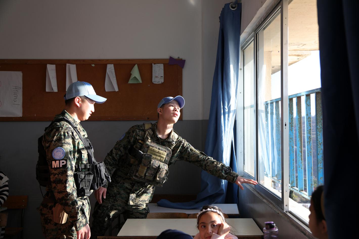 Two peacekeepers checking the installation of a window