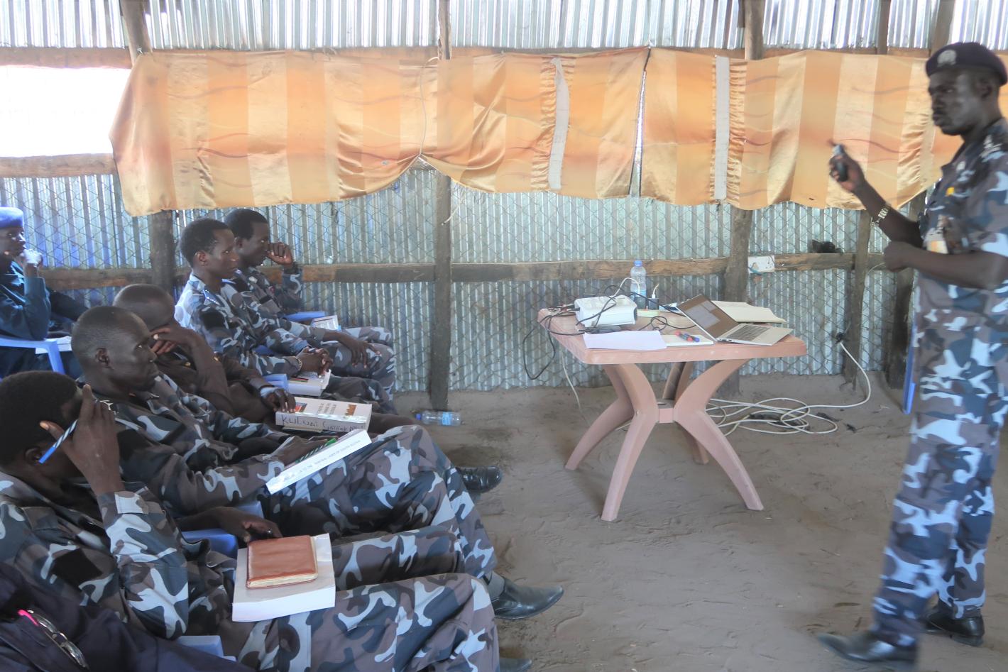 In preparation for the scheduled arrival of a mobile court in Leer, 20 national police officers have been trained to improve their investigative skills. Photo by Jacob Ruai/UNMISS. A group of uniformed police officers sitting watching a presentation being given by another uniformed person.